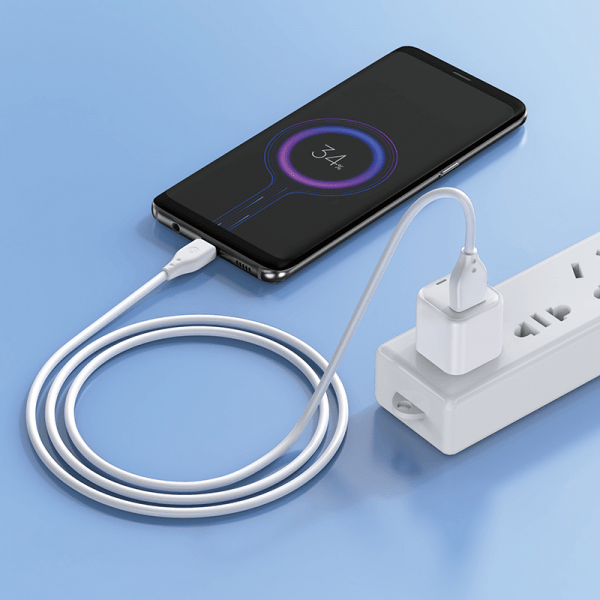 White USB-C charging cable plugged into a power adapter, coiled length