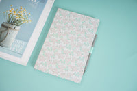Floral notebook with pink-speckled cover and attached pen