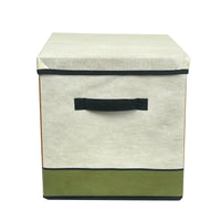 Foldable storage box with lid closed, cream front with black strap handle, green base strip.