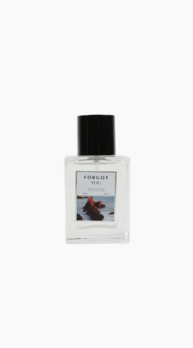 Eau de toilette bottle with black cap and seascape label on clear glass