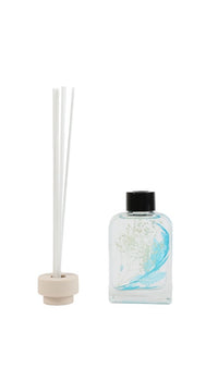 Blue bell reed diffuser bottle with black cap, blue splash glass, and white reeds