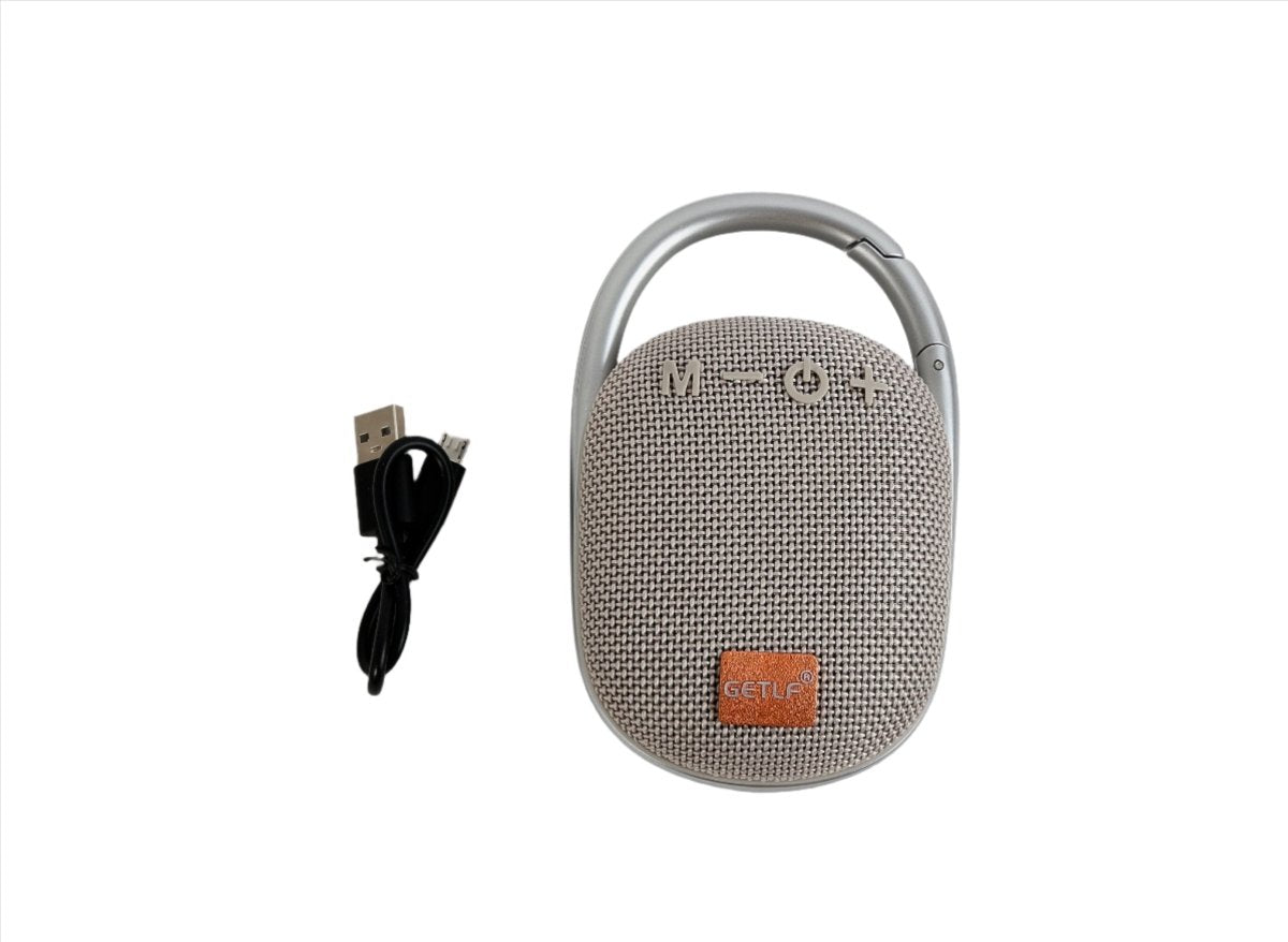 Light gray portable wireless speaker with handle, fabric grille, and USB cable