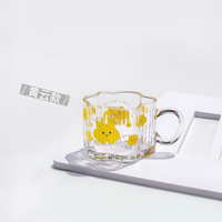 Clear glass mug with yellow bear and rain-cloud print, loop handle
