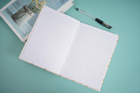 Open notebook with lined pages and pen resting on top