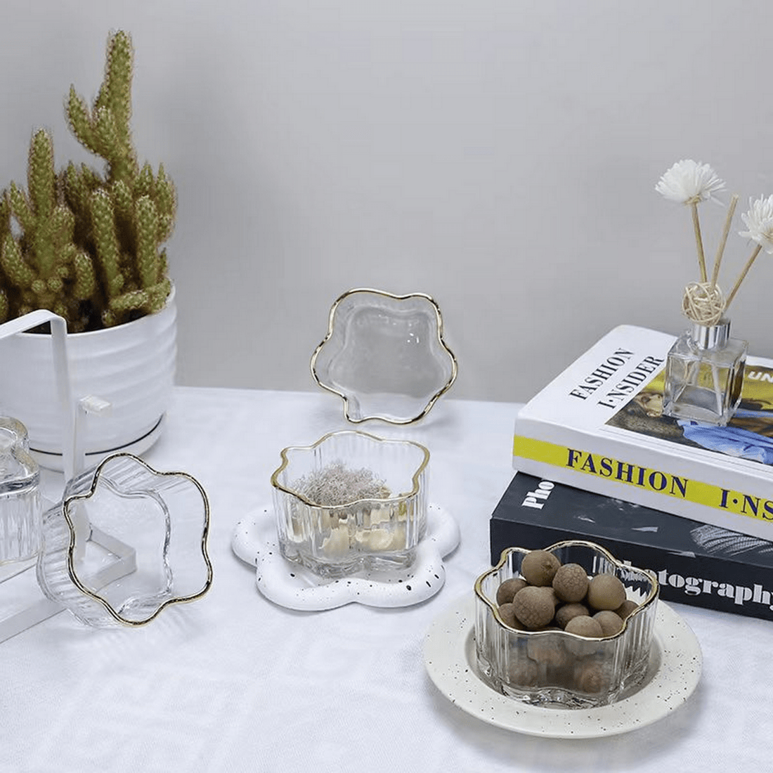 Glass flower bowl with gold-toned rim and scalloped petal edges, clear finish.
