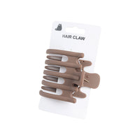 Taupe hair claw with multiple curved prongs on card backing