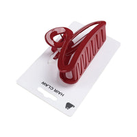 Red hair claw clip with ridged grip teeth, side view on card