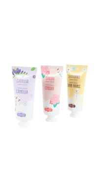 Three hand cream tubes: Camellia, Sakura Ceriser, and Chamomile in pastel labels