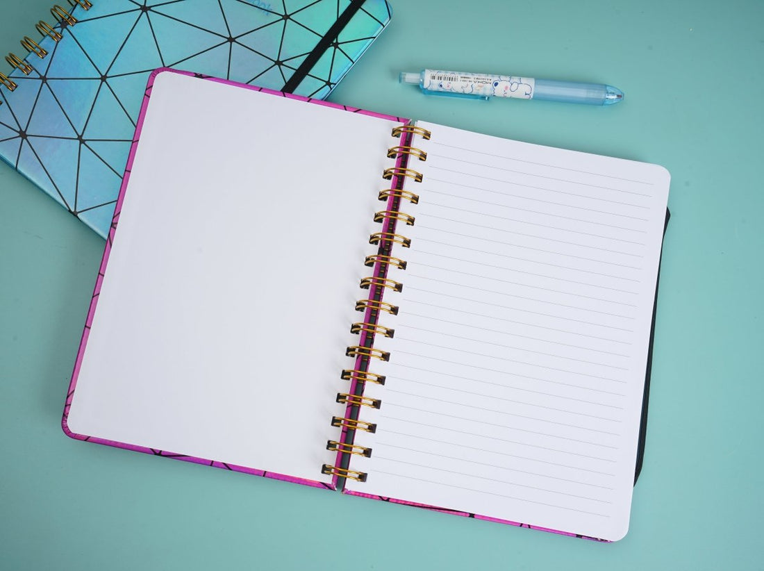 Holographic geometric notebook, blue cover, gold spiral, open lined pages