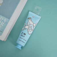 I'm Milk hand cream tube, light blue, label facing forward on flat surface