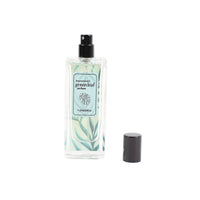 Women’s perfume bottle with green label and black spray cap, plus separate cap