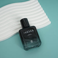 JAKSAA men's perfume bottle on white ribbed surface, black cap