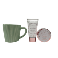 Gift set with green mug, body lotion tube, and bath salt tin with rose-gold rim