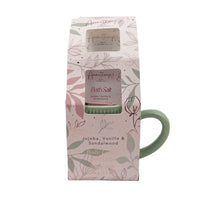 Floral-pattern gift bag with cutout showing bath salt and green mug handle