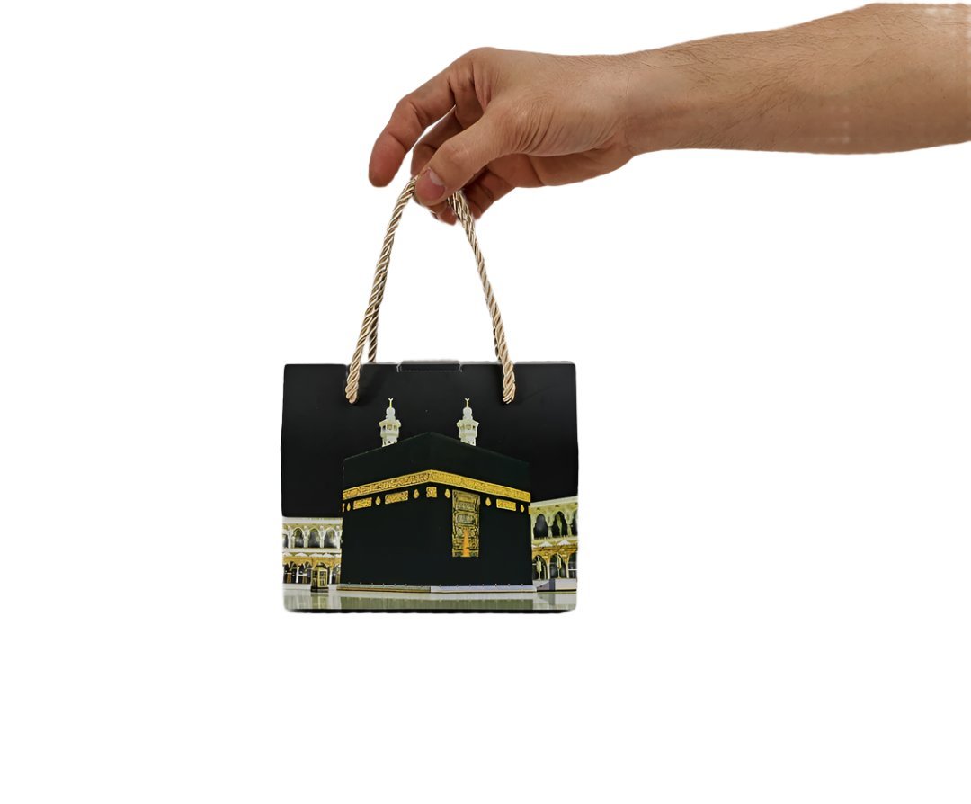 Kaaba gift box packaging held by hand with braided rope handles and Kaaba print