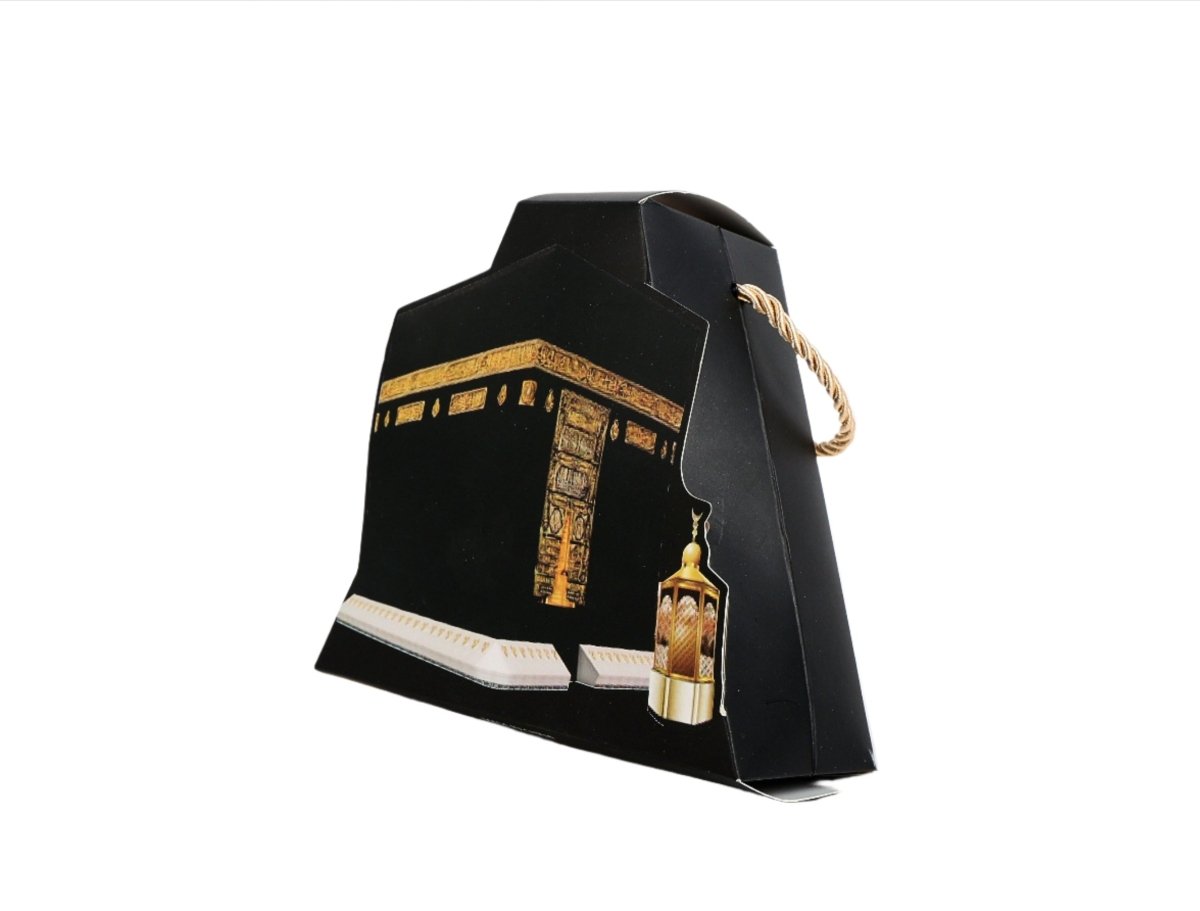 Kaaba-shaped box, black with gold Kaaba print, rope handle, small lantern.