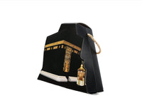 Kaaba-shaped box, black with gold Kaaba print, rope handle, small lantern.
