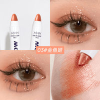 Golden orange shimmer eyeshadow on eyelid with pen shown