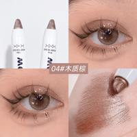 Shimmer eyeshadow pen applying bronze glitter near eye, pen and eyelid visible