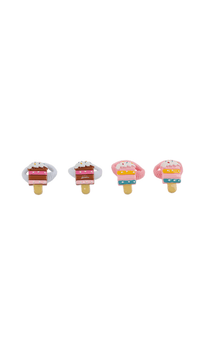 Four cake-top hair ties on cone-shaped bases in pink, blue, and caramel tones