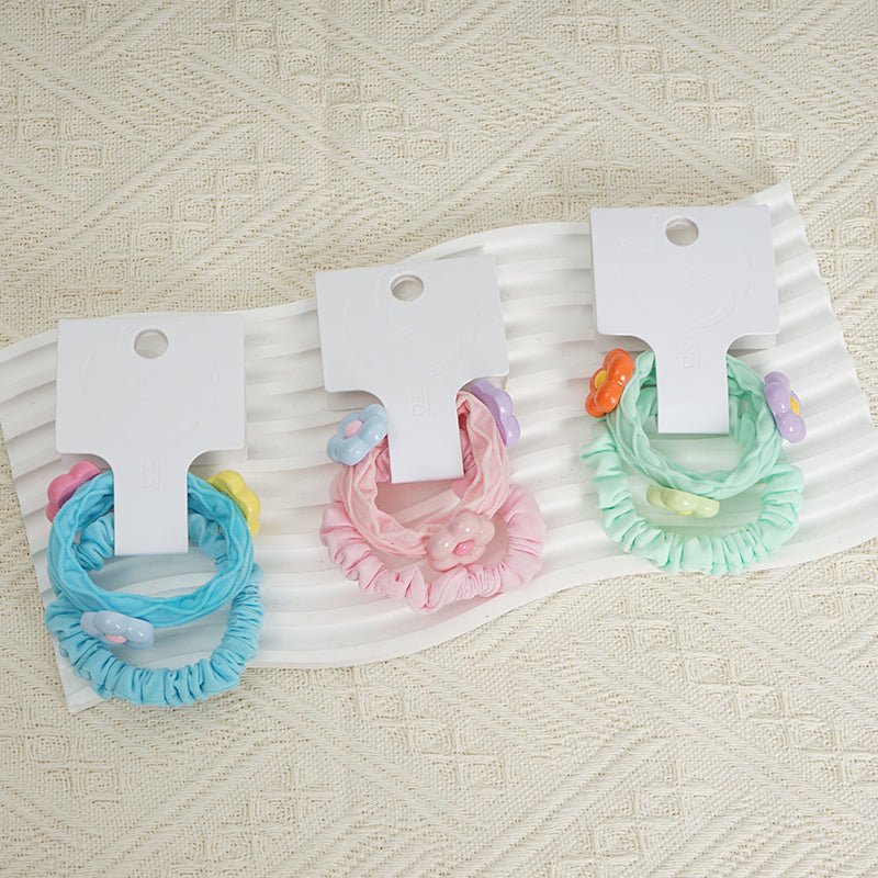 Flower hair ties set: blue, pink, and mint ruffled fabric loops on display cards