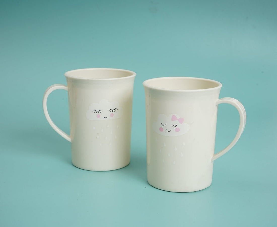 Kids toothbrush cups, two white mugs with face designs and handles