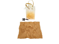 White gift bag with straw filler and brown towel pouch with black bow