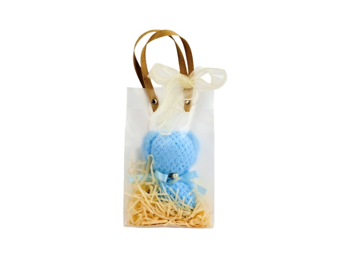 Blue towel bear in small gift bag with bow handle and straw filler