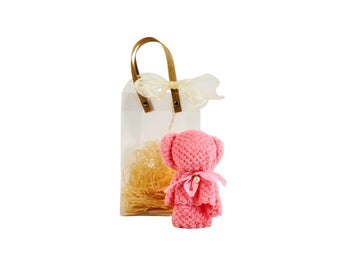 Pink towel bear in small gift bag with bow handle and straw filler
