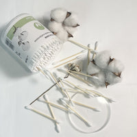 Double-headed cotton swabs spilling on tray with open jar