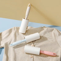 Lint roller with white handle and white sticky roller for removing lint from fabric