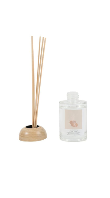 Reed diffuser set with amber lily scent, clear glass bottle, wood base, reed sticks