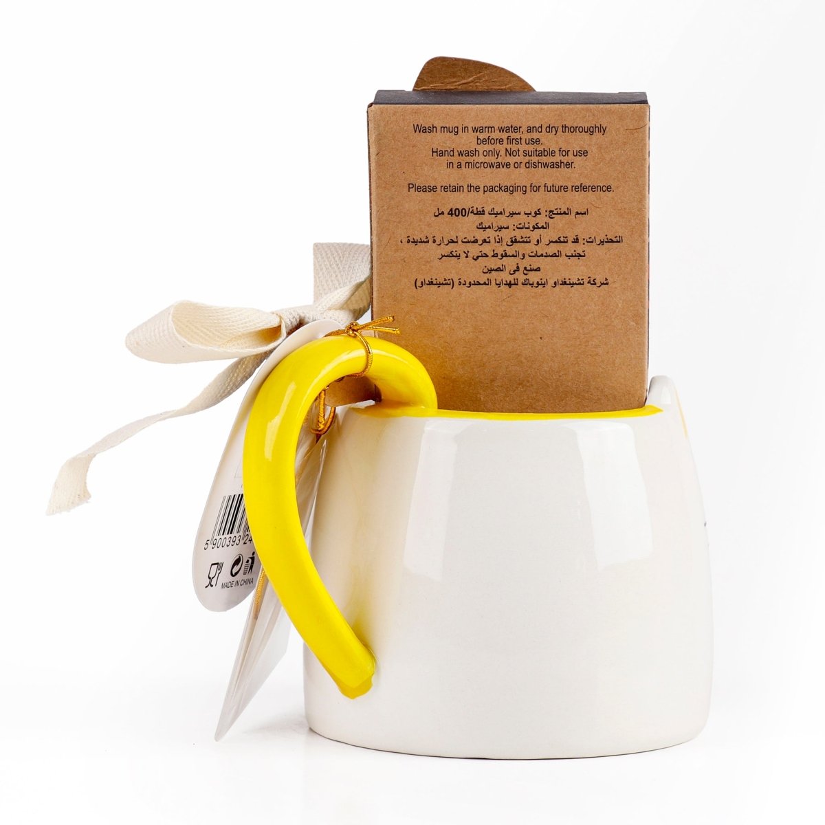 White ceramic cat mug with yellow handle, care instructions on cardboard sleeve