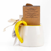White ceramic cat mug with yellow handle, care instructions on cardboard sleeve