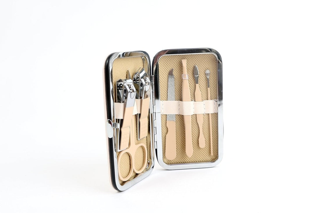 Manicure and pedicure set tools in two-part open metal case with patterned insert
