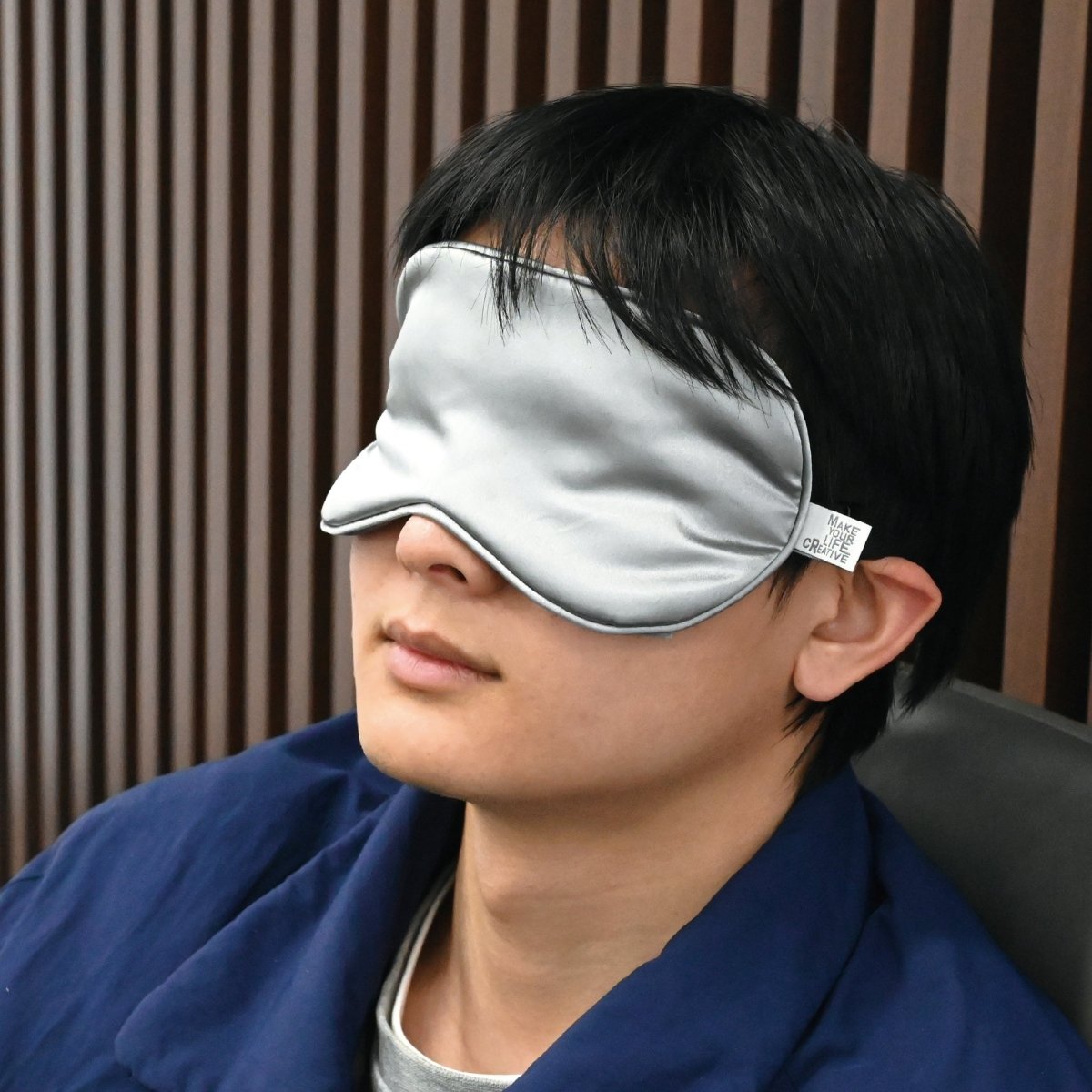 Silk eye cooling sleep mask on a person, light gray and black-trimmed