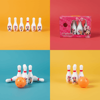 Child bowling set with white Minnie Mouse pins and pink bow, plus orange ball in box