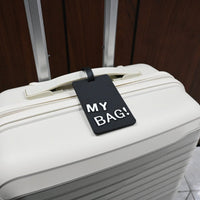 Luggage ID tag on a white suitcase, red “MY BAG!” card and black strap.