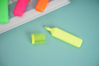 Neon yellow highlighter with chisel tip, plus small yellow marker cap.