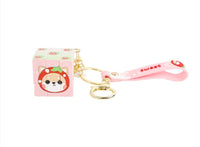 Pink cube keychain with bear face cube charm, gold keyring, and bell