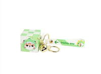Green cube keychain with animal illustration strap, gold keyring, and bell