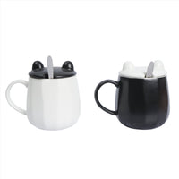 Two ceramic panda cups with lids and spoons, one white and one black