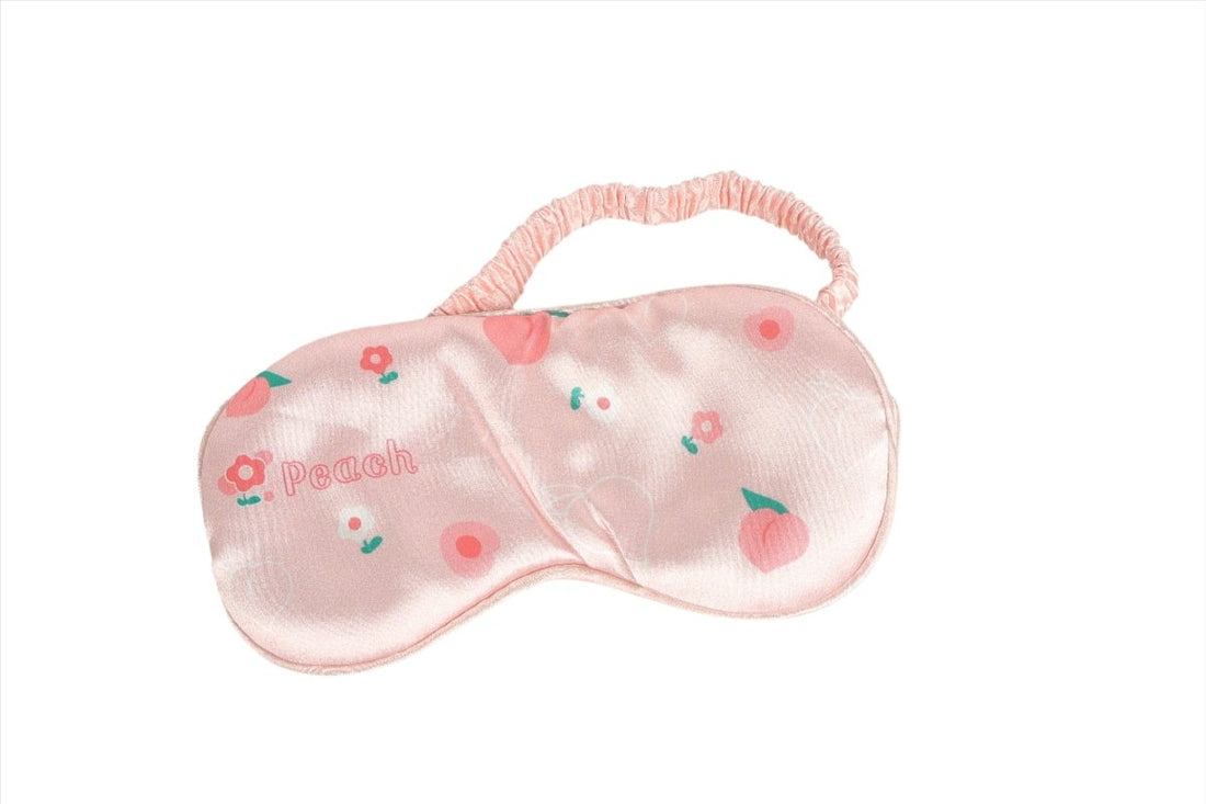 Peach pink silk sleep mask with peach and flower motifs, curved eye cover