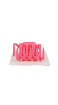 Pink plastic hair clip, side view with finger grips and teeth