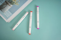 Three pink highlighters with white barrels, pink ends, and red accents