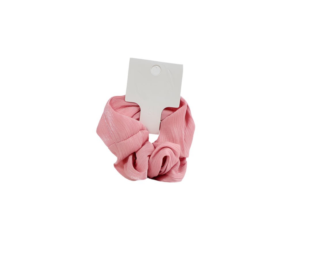 Pink hair scrunchie with woven texture and attached white product tag