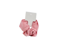 Pink hair scrunchie with woven texture and attached white product tag