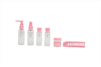 Pink travel toiletry set with 4 bottles, small jars, and pink comb