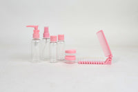 Pink travel toiletry set with pump bottle, mini bottles, jar, and folding comb