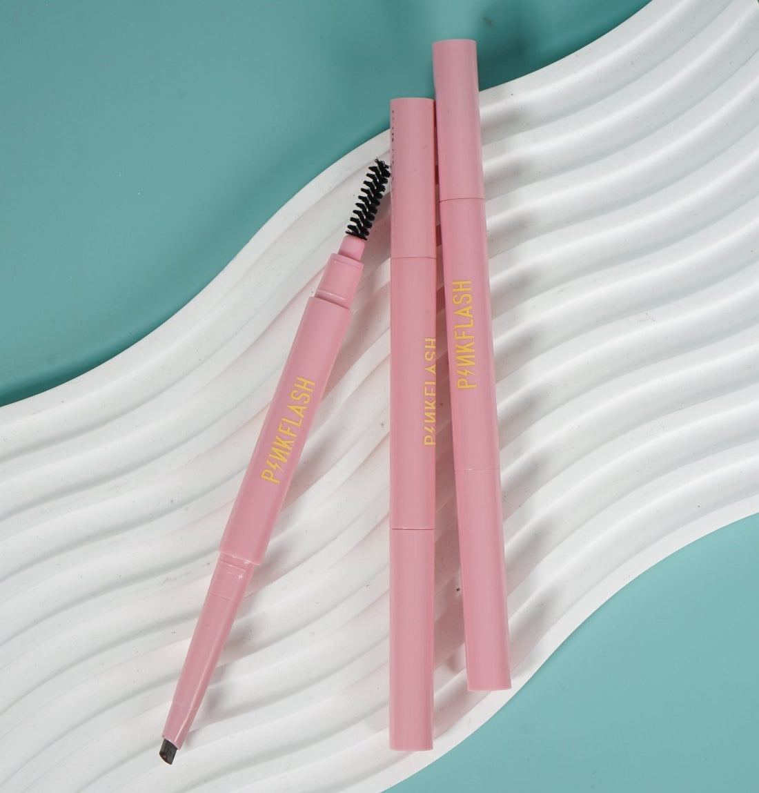 Dual-ended eyebrow pencil with spoolie brush, pink barrel, slim tip for defining brows